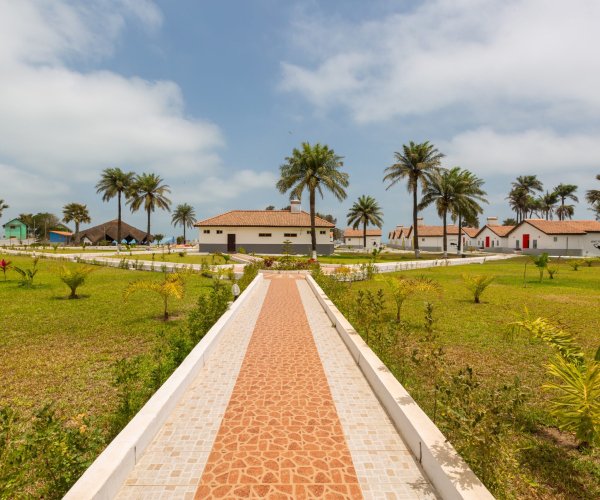 A beautiful pavement and the houses surrounded by grassy fields captured in Gambia, Africa